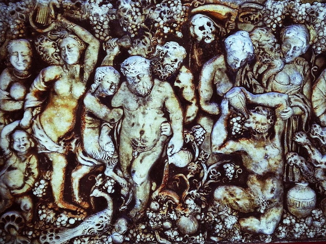 An ancient book open to a yellowed page, illustrations of gods and monsters visible
